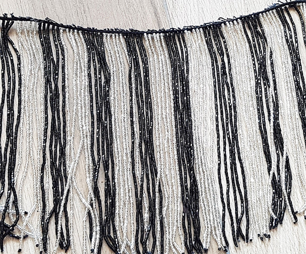 Beaded string with black/white strings with many beads

 60cm long, strands 20cm long